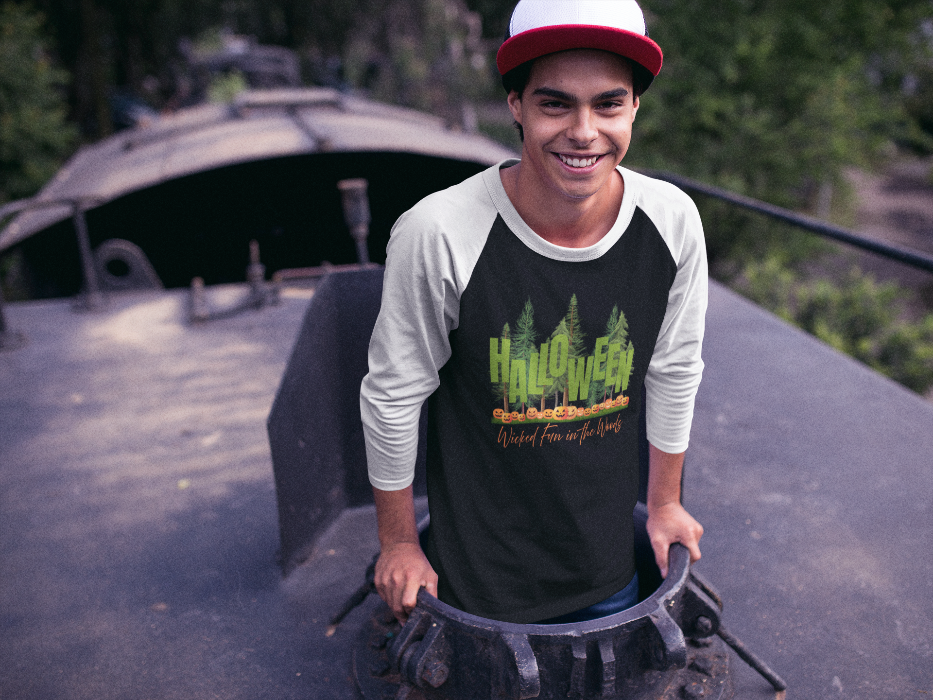 Man wearing a black t-shirt with a graphic of a forest and Jack-o-lanterns, standing on a rooftop with text "Halloween - Wicked Fun in Woods" by 515Gear.com