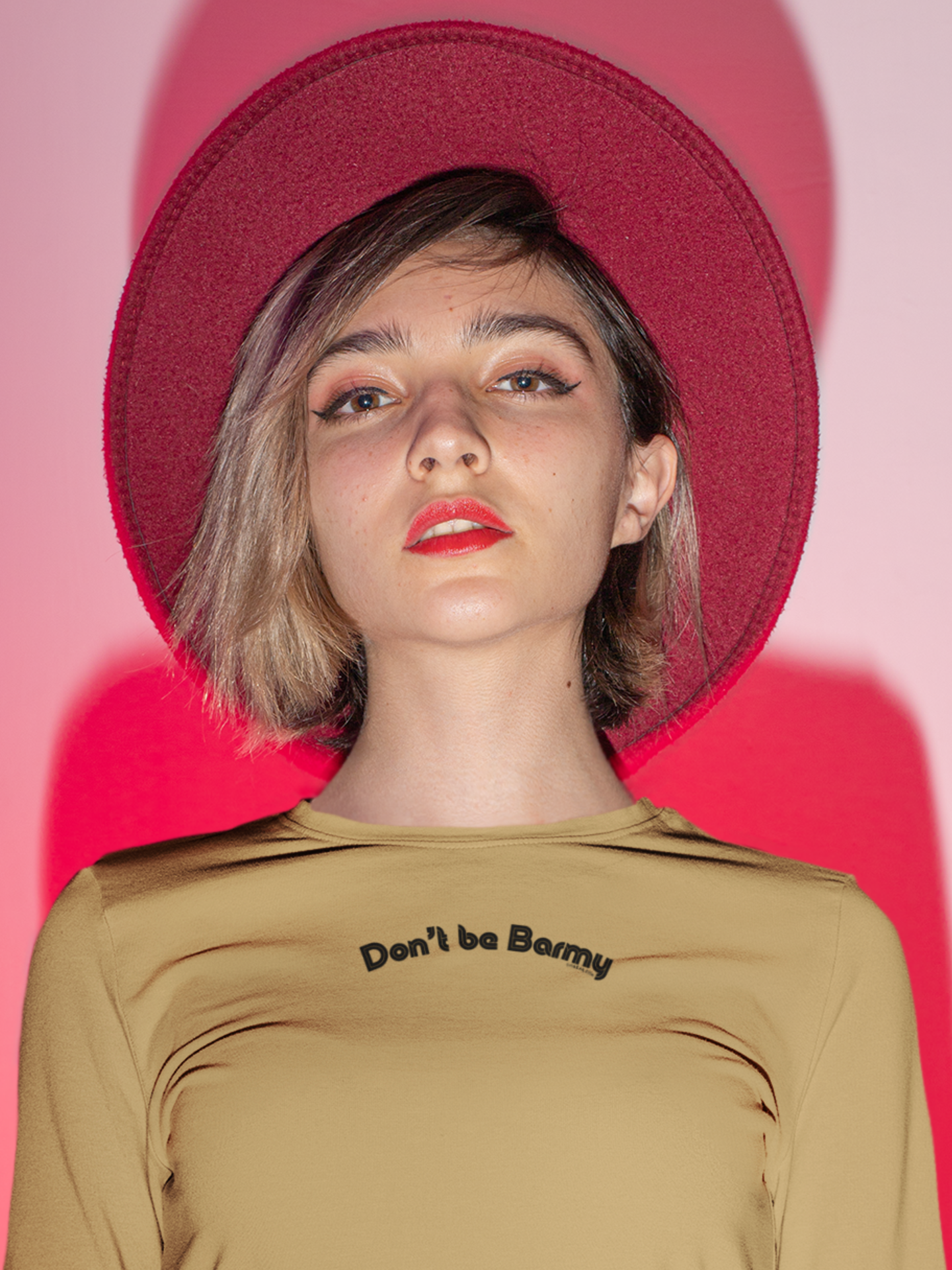 Person wearing a mustard long sleeve t-shirt with text "Don't be Barmy"