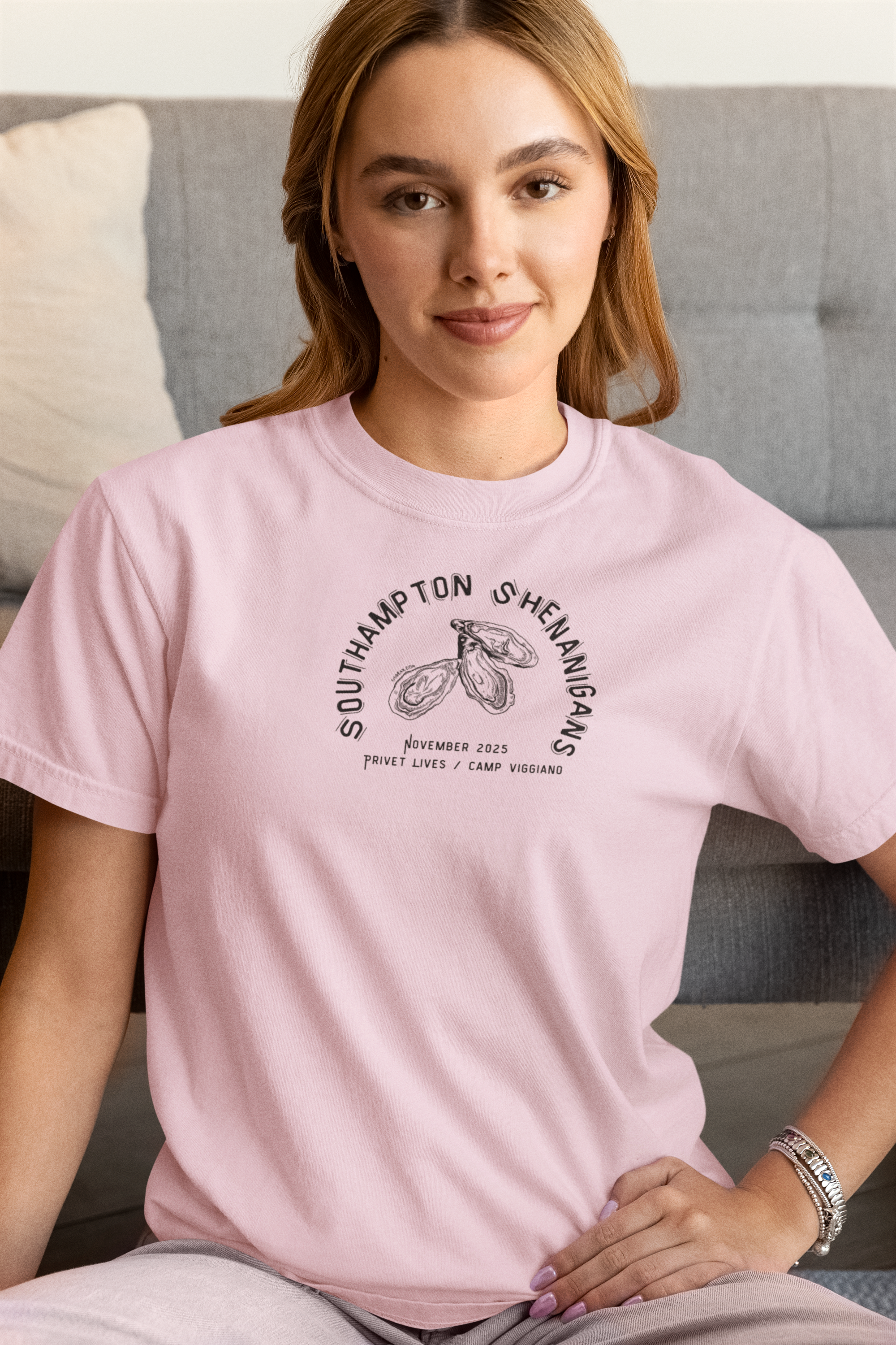 Woman wearing a pink t-shirt with Oyster graphic and text "Southampton Shenanigans November 2025 Privet Lives Camp Viggiano"