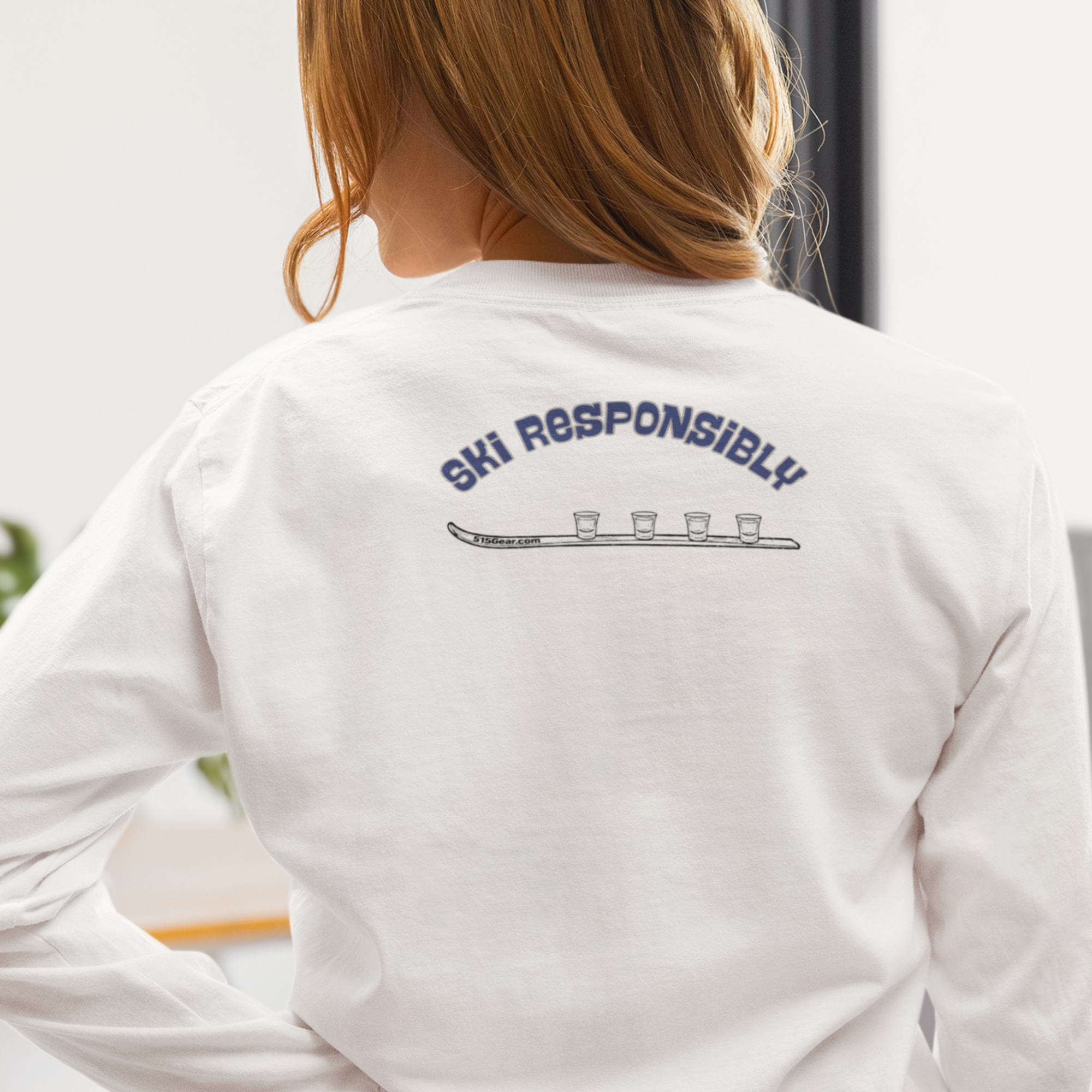 Woman wearing a white unisex Comfort Colors long sleeve team and text 'Ski Responsibly' next to a Shotski graphic