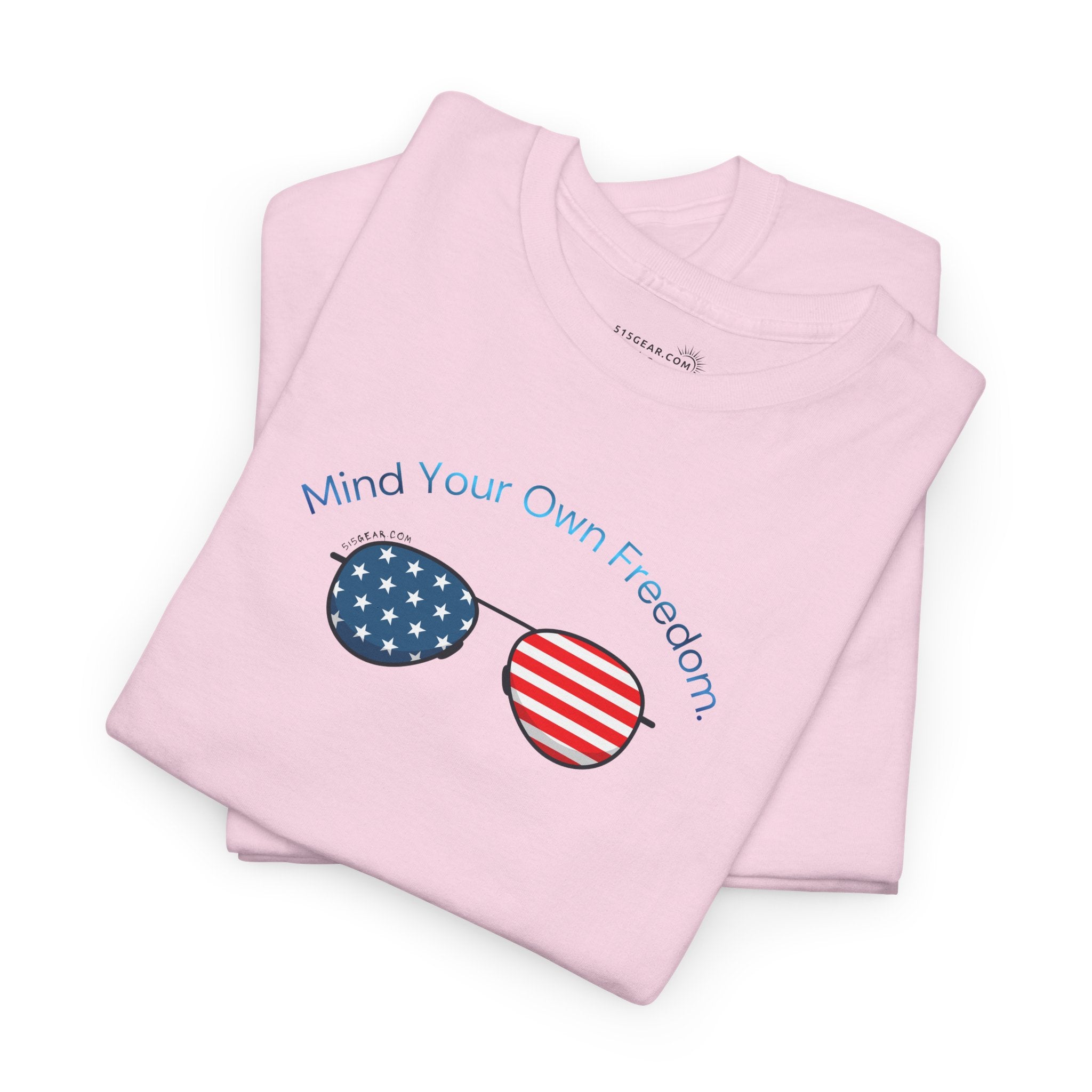 Folded pink t-shirt with American Flag sunglasses and text "Mind Your Own Freedom"