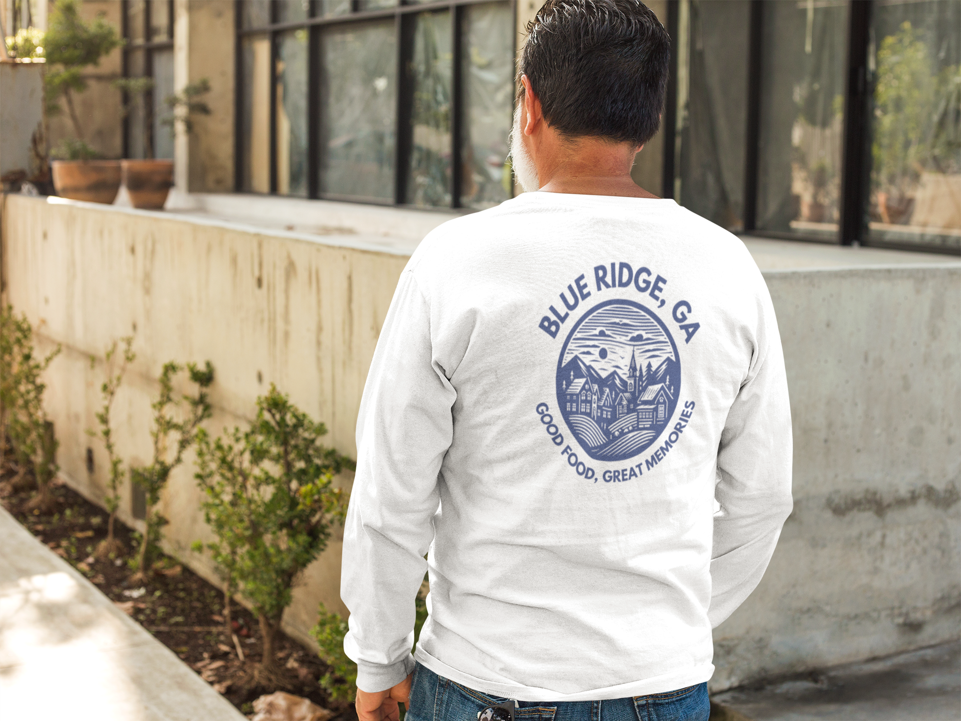man wearing white comfort colors long sleeve t-shirt with blue ridge on the back