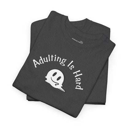 Folded black t-shirt with 'Adulting is Hard' text and ghost graphic on a white background