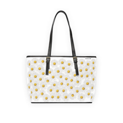 White tote bag with yellow floral daisy pattern and black straps on a white background