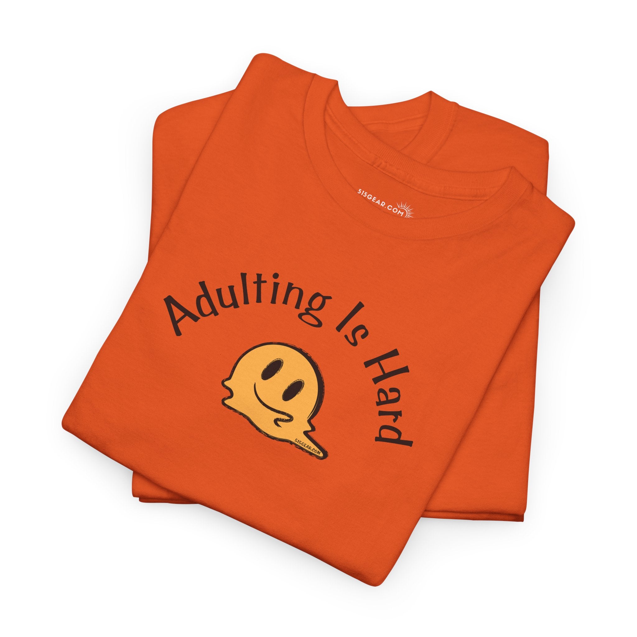 Orange t-shirt with 'Adulting is Hard' text and smiley face on a white background