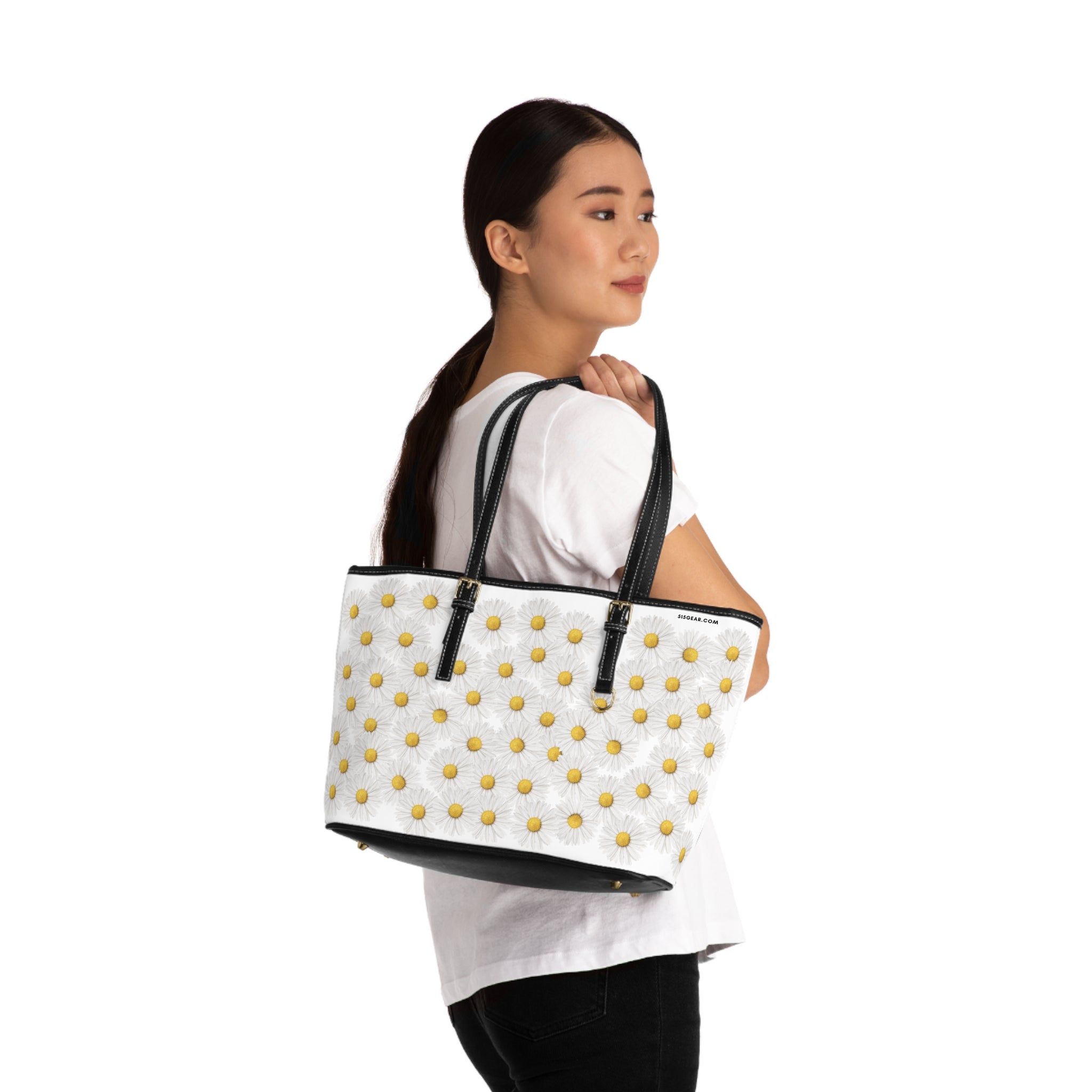 Woman carrying a white tote bag with daisies graphic on a white background