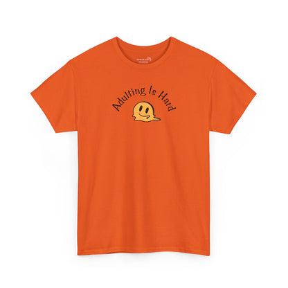 Orange Gildan Unisex 100% Heavy Cotton soft t-shirt, with smiley face graphic and text "Adulting is Hard"