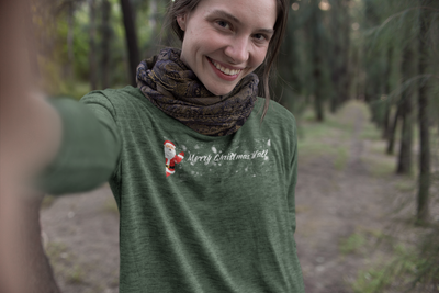 Woman in a green long-sleeve shirt with Santa waving and text "Merry Christmas Y'all"