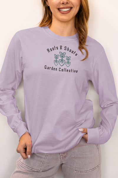 Person wearing a lavender long-sleeve shirt with 'Roots & Shoots Garden Collective' logo.