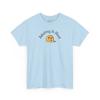 Light blue Gildan Unisex 100% Heavy Cotton soft t-shirt, with smiley face graphic and text "Adulting is Hard"