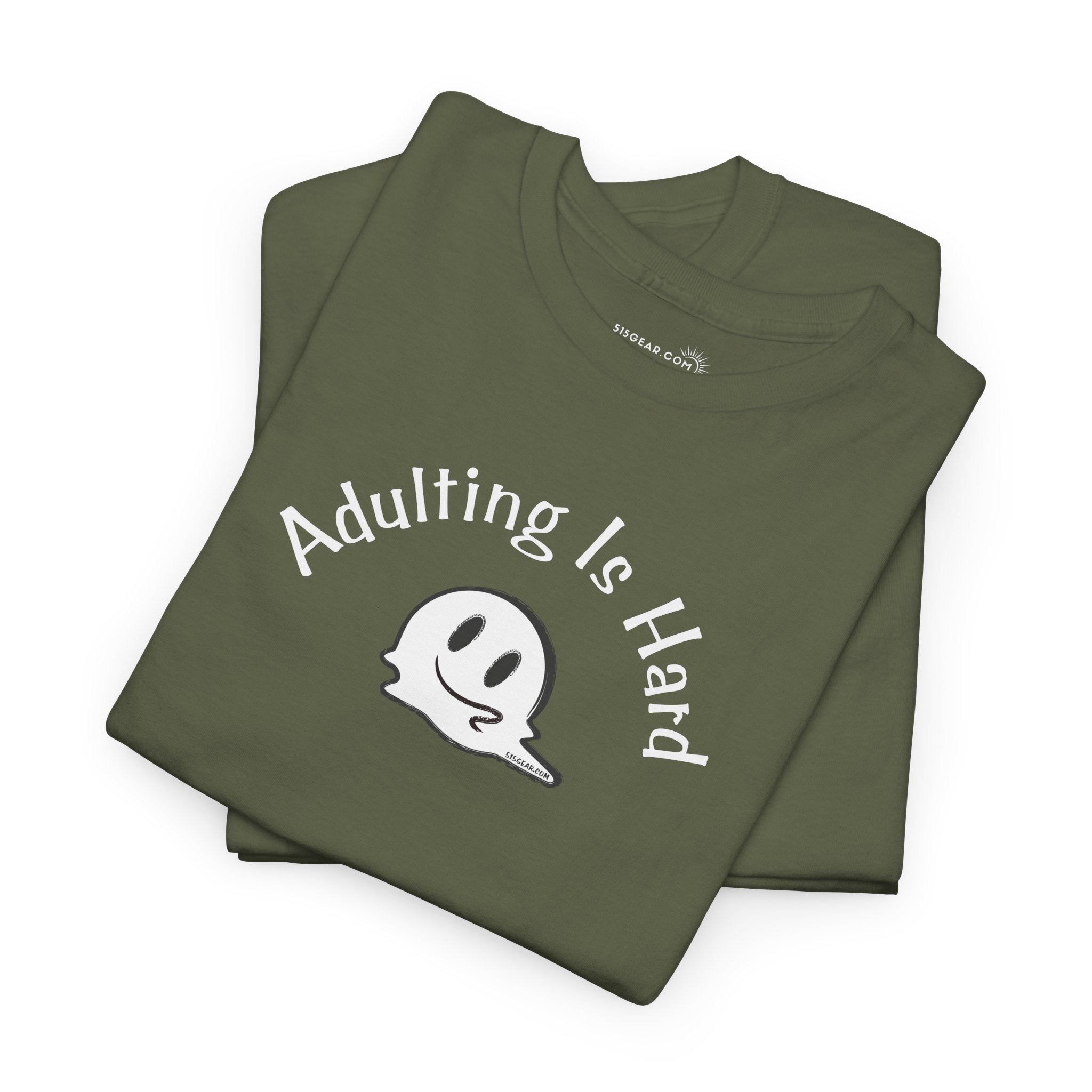 Folded green t-shirt with 'Adulting is Hard' text and ghost graphic on a white background