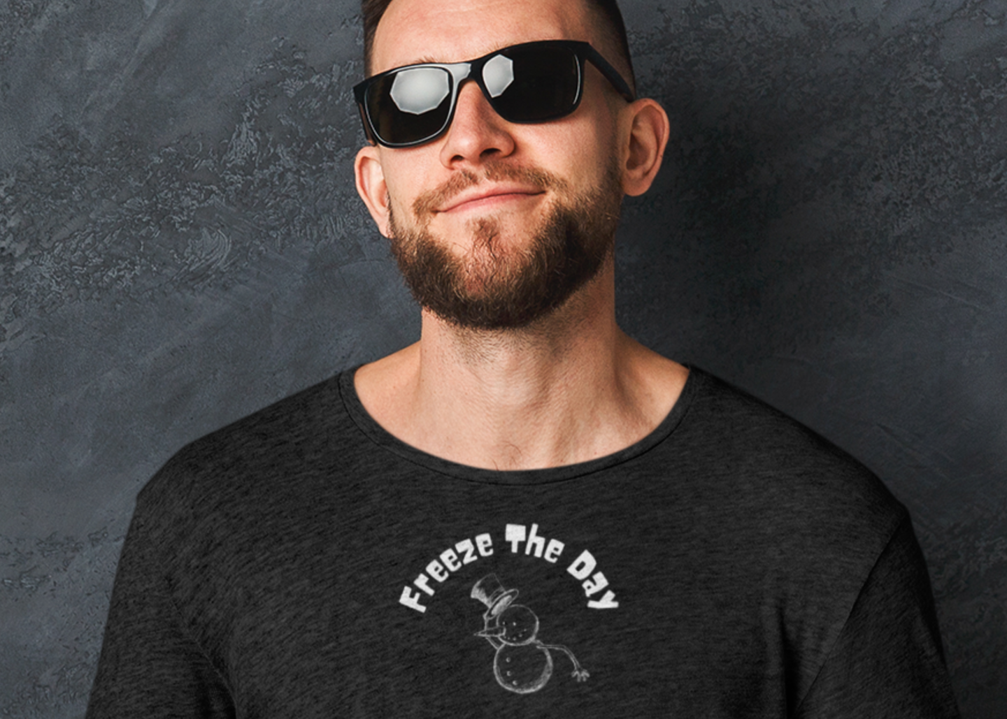 Man wearing sunglasses and a black long-sleeve shirt with 'Freeze The Day' design, holding a coffee cup against a dark background.
